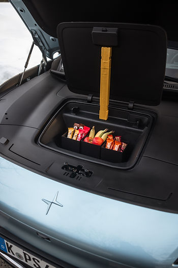 Offener vorderer Kofferraum eines Autos mit mehreren Snacks und Getränken darin