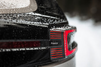 Nahaufnahme des Heckbereichs eines schwarzen Polestar-Fahrzeugs mit Wassertropfen auf der Oberfläche und markantem Rücklichtdesign