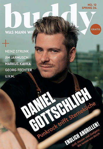 Mann mit braunem Haar und braunen Hosenträgern vor unscharfem Stadt-Hintergrund auf dem Cover der Zeitschrift 'buddy' mit dem Titel 'DANIEL GOTTSCHLICH Punkrock trifft Sterneküche'