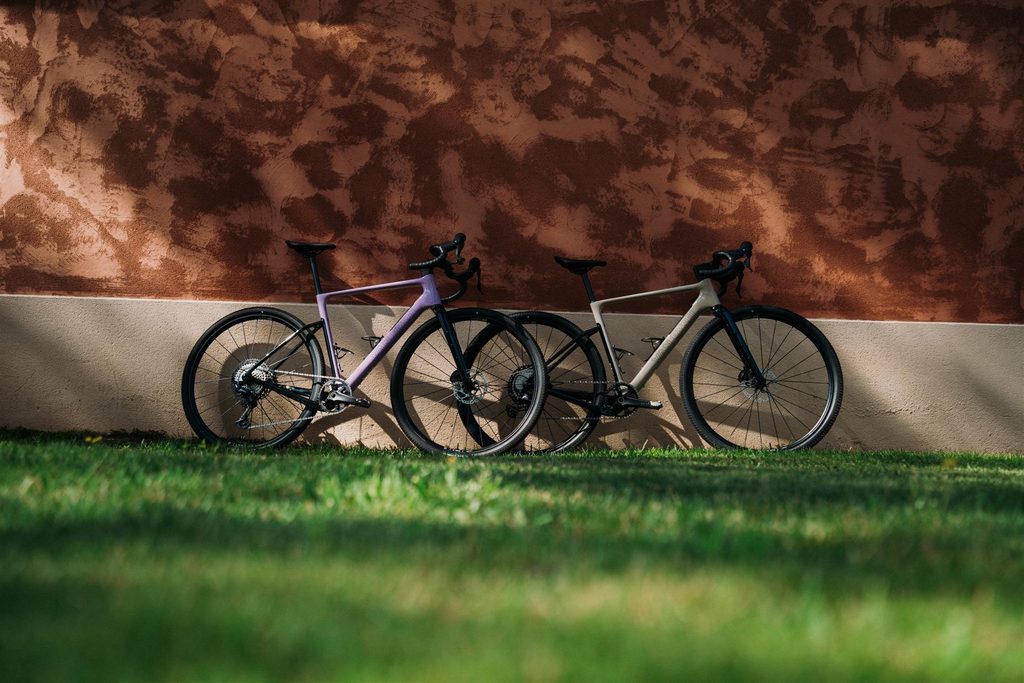 Zwei Van Rysel EDR-G Gravelbikes vor einer rotbraunen Wand